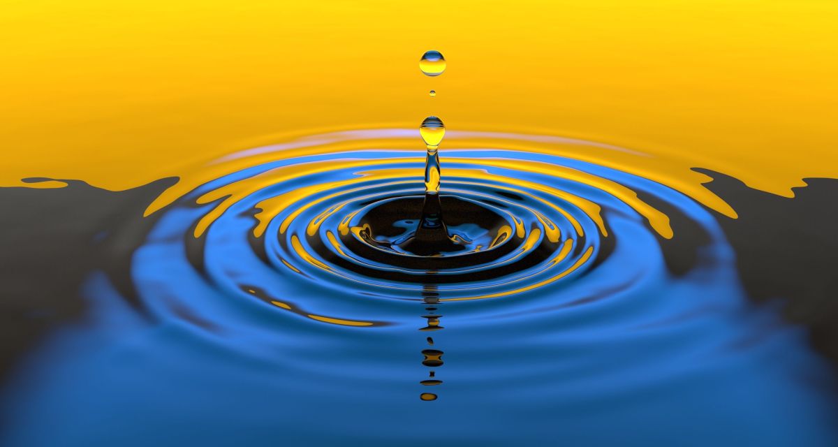 A water droplet rippling on a clear surface